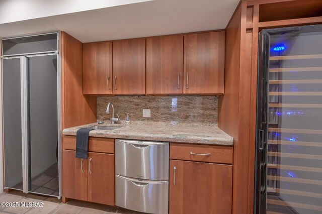 kitchen featuring wall chimney range hood, sink, hanging light fixtures, built in appliances, and a center island with sink