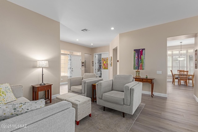 living area featuring recessed lighting, wood finished floors, visible vents, and baseboards