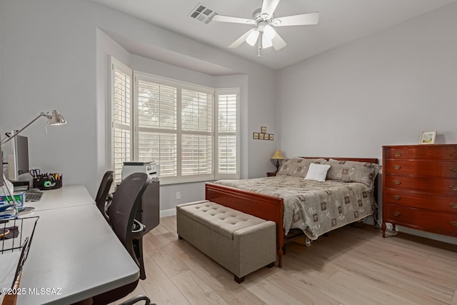 bedroom featuring light wood-type flooring, ceiling fan, visible vents, and baseboards