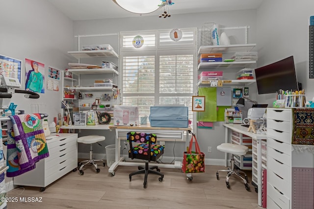 home office with light wood-style flooring and baseboards