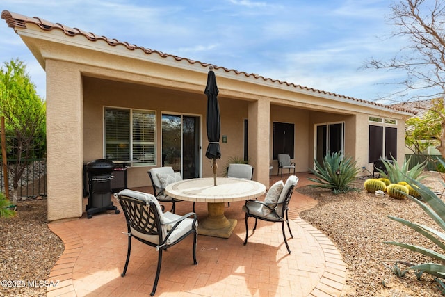 view of patio with outdoor dining area, grilling area, and fence