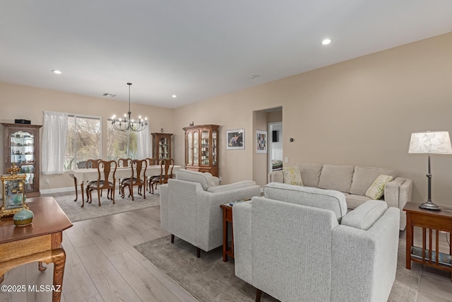 living room with recessed lighting, baseboards, a notable chandelier, and light wood finished floors