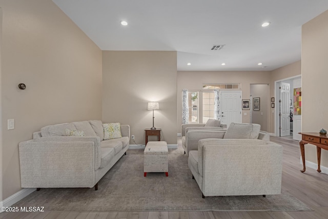 living area with baseboards, visible vents, wood finished floors, and recessed lighting