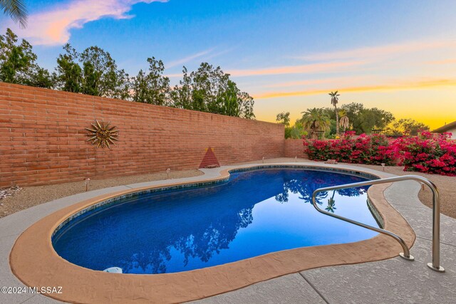 view of pool at dusk