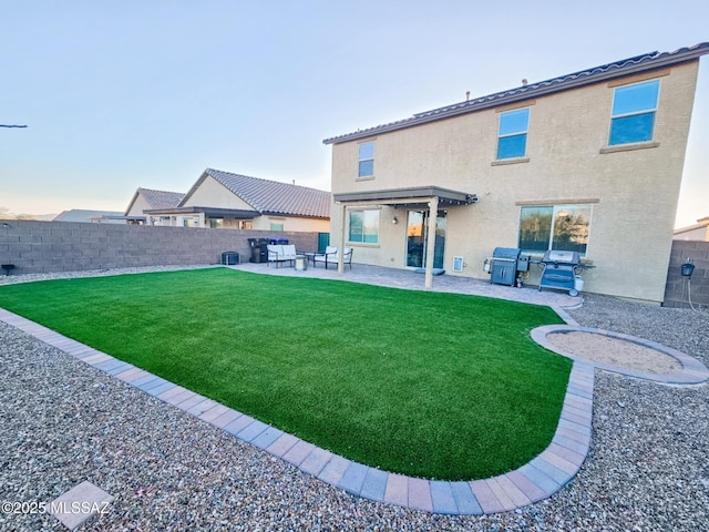 rear view of property with a patio area, fence, a lawn, and stucco siding