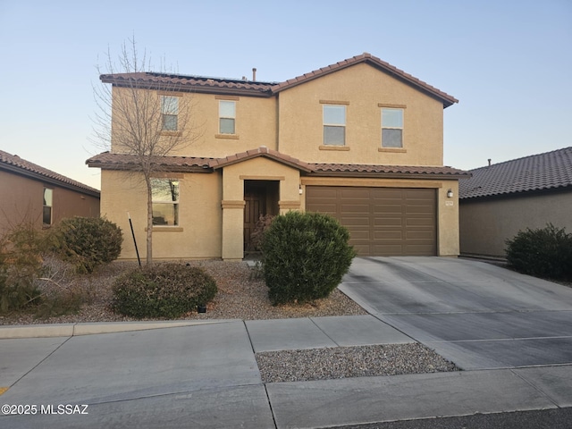 view of front facade featuring driveway, a tile roof, a garage, and stucco siding