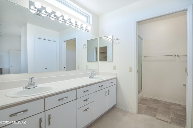 bathroom with vanity and a shower with door