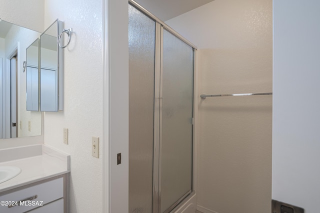 bathroom featuring vanity and a shower with shower door