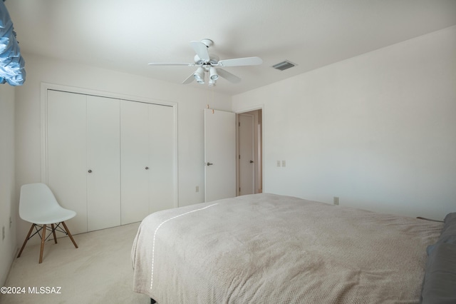 bedroom featuring light carpet, a closet, and ceiling fan