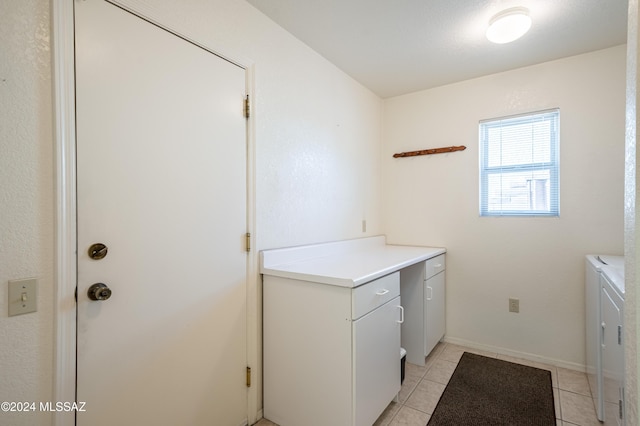 washroom with cabinets, washer and clothes dryer, and light tile patterned floors