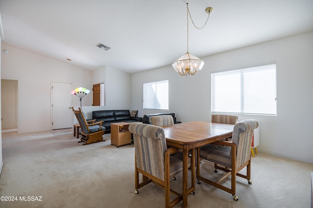 carpeted dining room featuring vaulted ceiling and a chandelier