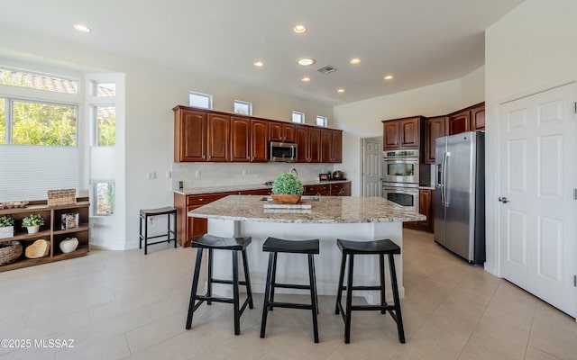 kitchen with a wealth of natural light, a breakfast bar area, stainless steel appliances, and a kitchen island