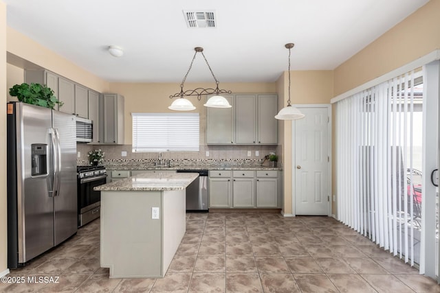 12996 N Desert Olive Dr, Oro Valley, AZ 85755 - kitchen with gray cabinetry, hanging light fixtures, appliances with stainless steel finishes, a kitchen island, and decorative backsplash