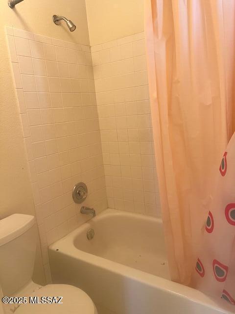 bathroom with shower / bath combo and toilet