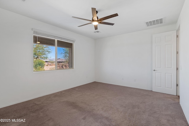 unfurnished room with visible vents, carpet floors, and ceiling fan