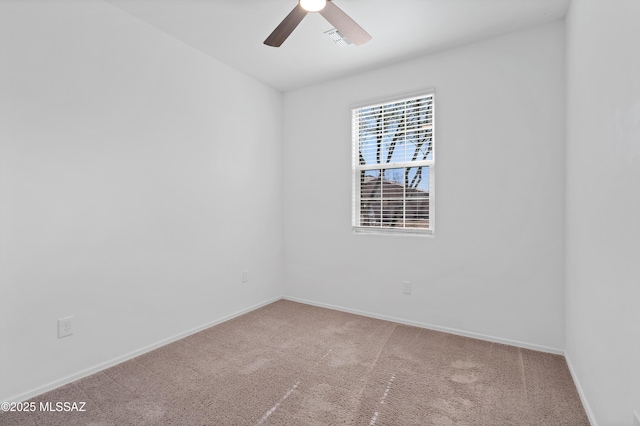 empty room with visible vents, carpet, baseboards, and ceiling fan