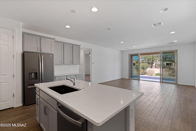 kitchen with visible vents, gray cabinets, a sink, appliances with stainless steel finishes, and open floor plan