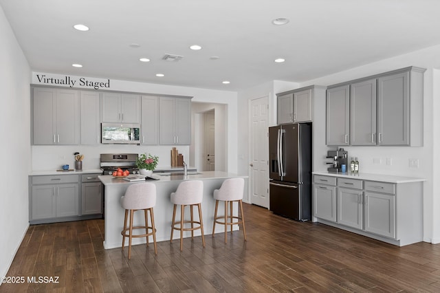 kitchen with visible vents, gray cabinets, stainless steel appliances, and dark wood-style flooring