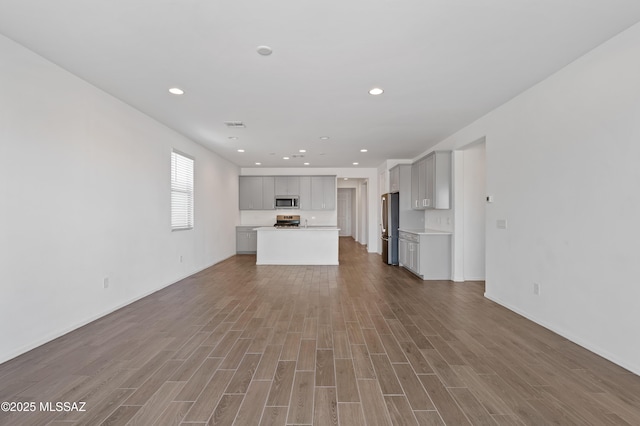 unfurnished living room featuring visible vents, recessed lighting, and wood finished floors