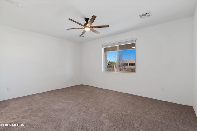 carpeted empty room with visible vents and a ceiling fan