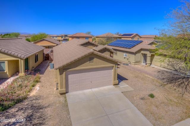 view of front facade featuring a garage and solar panels