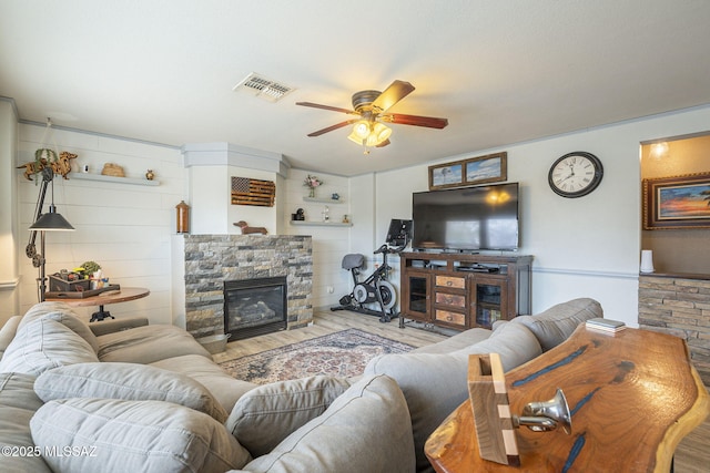 living room with ceiling fan, a fireplace, and light hardwood / wood-style floors