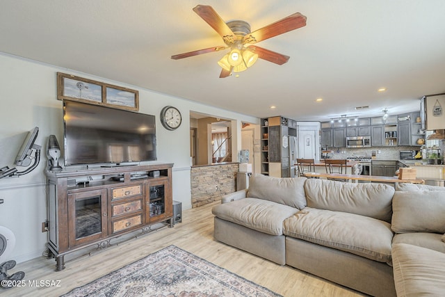 living room with ceiling fan and light wood-type flooring