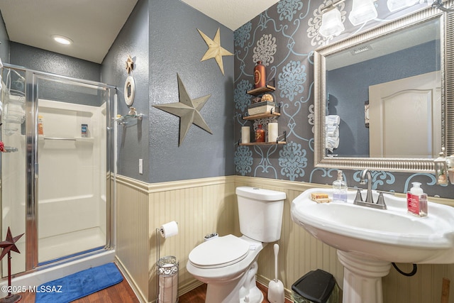 bathroom with walk in shower, toilet, sink, and hardwood / wood-style flooring