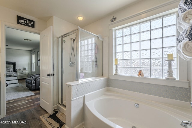 bathroom with hardwood / wood-style flooring and shower with separate bathtub