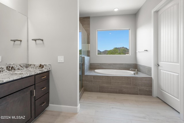 bathroom with vanity and independent shower and bath