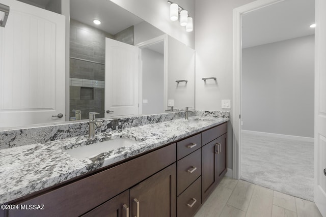 bathroom featuring vanity, hardwood / wood-style floors, and tiled shower