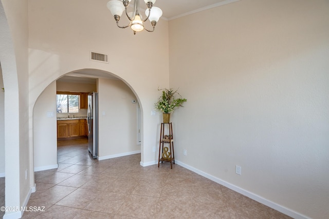 interior space with light tile patterned floors, arched walkways, baseboards, a notable chandelier, and visible vents