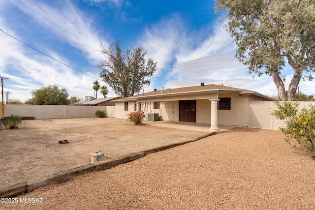 rear view of property featuring a fenced backyard, central air condition unit, and a patio