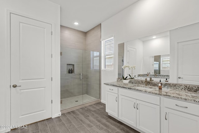 bathroom with vanity and a shower with shower door