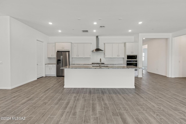 kitchen featuring white cabinets, black appliances, wall chimney exhaust hood, and light stone countertops