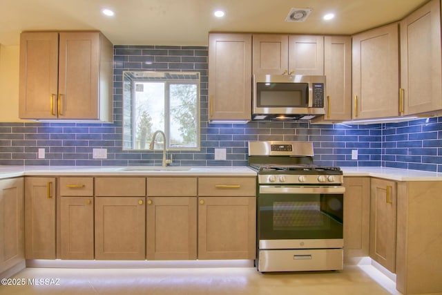 kitchen with appliances with stainless steel finishes, sink, and decorative backsplash