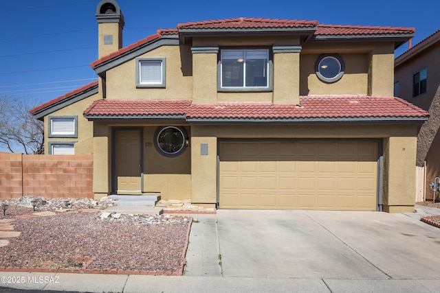 view of front facade with fence, a tile roof, concrete driveway, stucco siding, and an attached garage