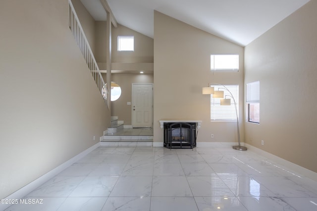 unfurnished living room featuring stairway, plenty of natural light, and marble finish floor