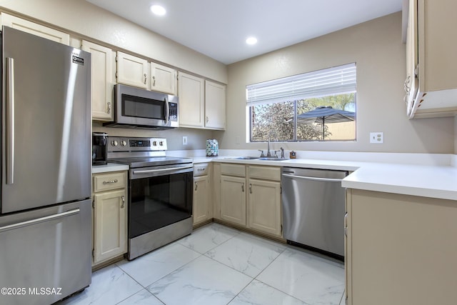 kitchen with a sink, stainless steel appliances, marble finish floor, and light countertops