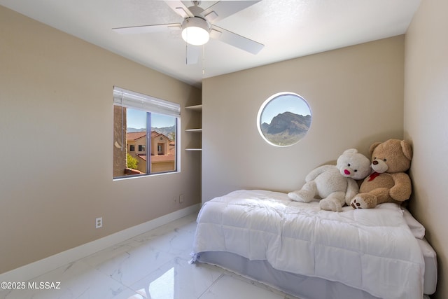 bedroom featuring a ceiling fan, baseboards, and marble finish floor