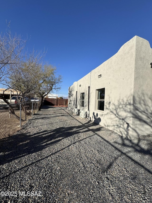 view of property exterior with fence and stucco siding