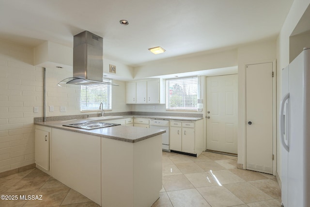 kitchen with island range hood, a peninsula, white appliances, a sink, and white cabinets