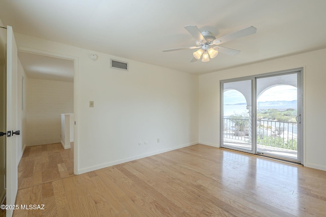 unfurnished room with visible vents, light wood-style flooring, and baseboards