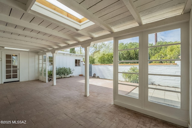 unfurnished sunroom with a skylight