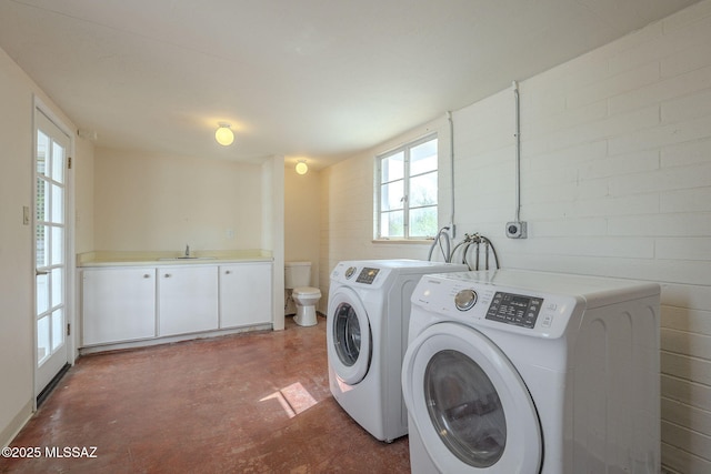 laundry room with a sink, laundry area, and washer and dryer