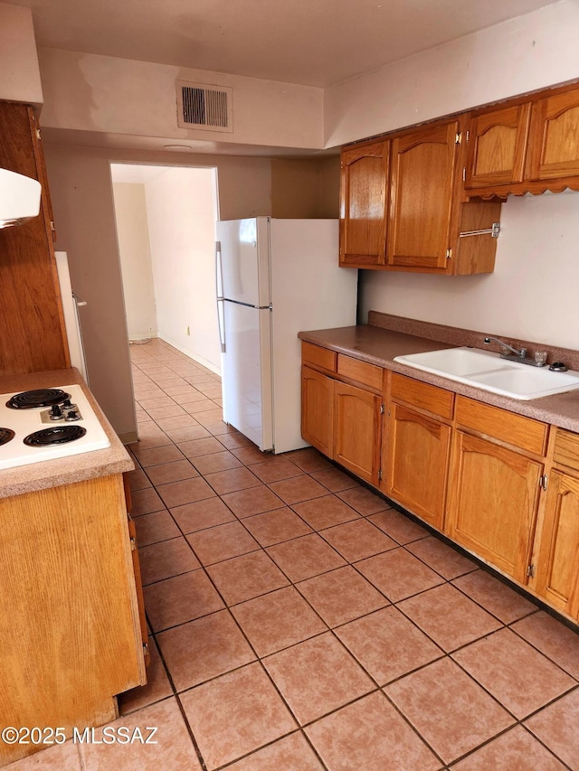 kitchen featuring light tile patterned flooring, white appliances, ventilation hood, and sink