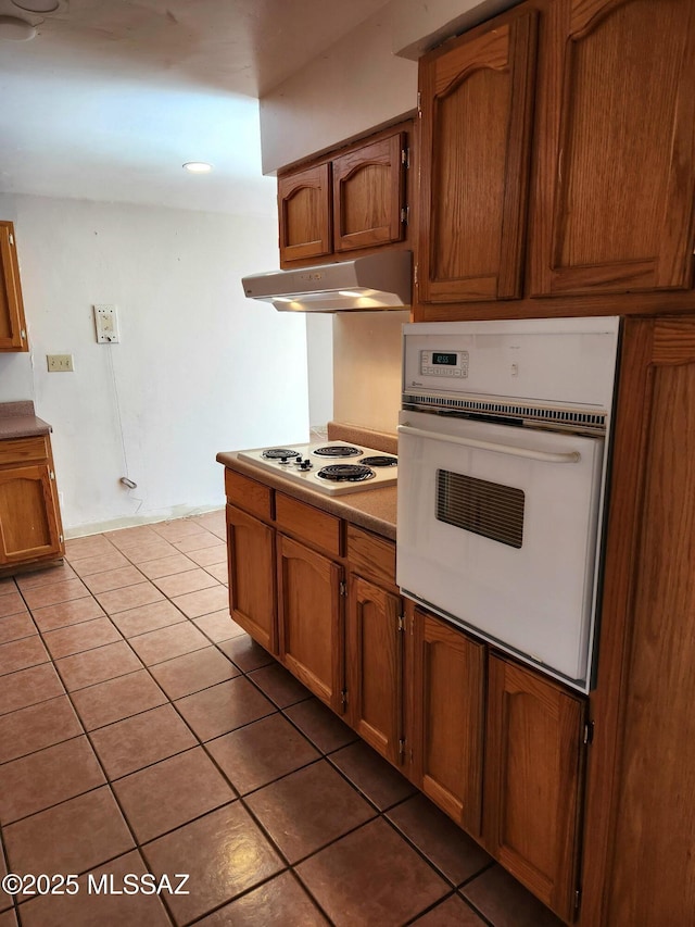 kitchen featuring light tile patterned floors and white appliances