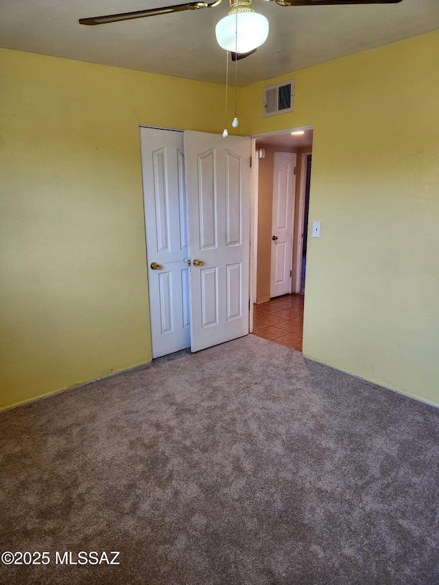 unfurnished bedroom featuring carpet floors and ceiling fan