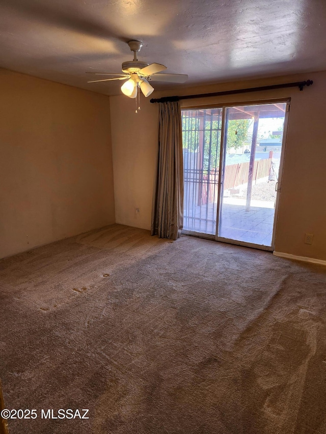 unfurnished room featuring ceiling fan and carpet