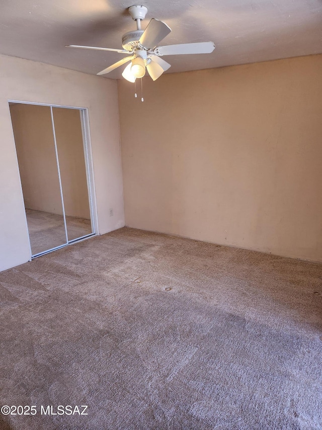 unfurnished bedroom with ceiling fan, a closet, and carpet